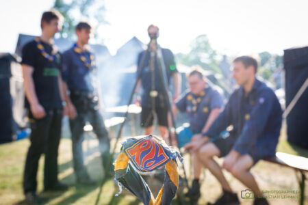 Ein abgenutztes Ranger/Rover Halstuch. Dahinter ein paar R/R beim grillen. Aussagekräftige Imagefotos von LS Photographie - Sebastian Lehmann für die Pfadfinder vom BdP LV NRW e.V.